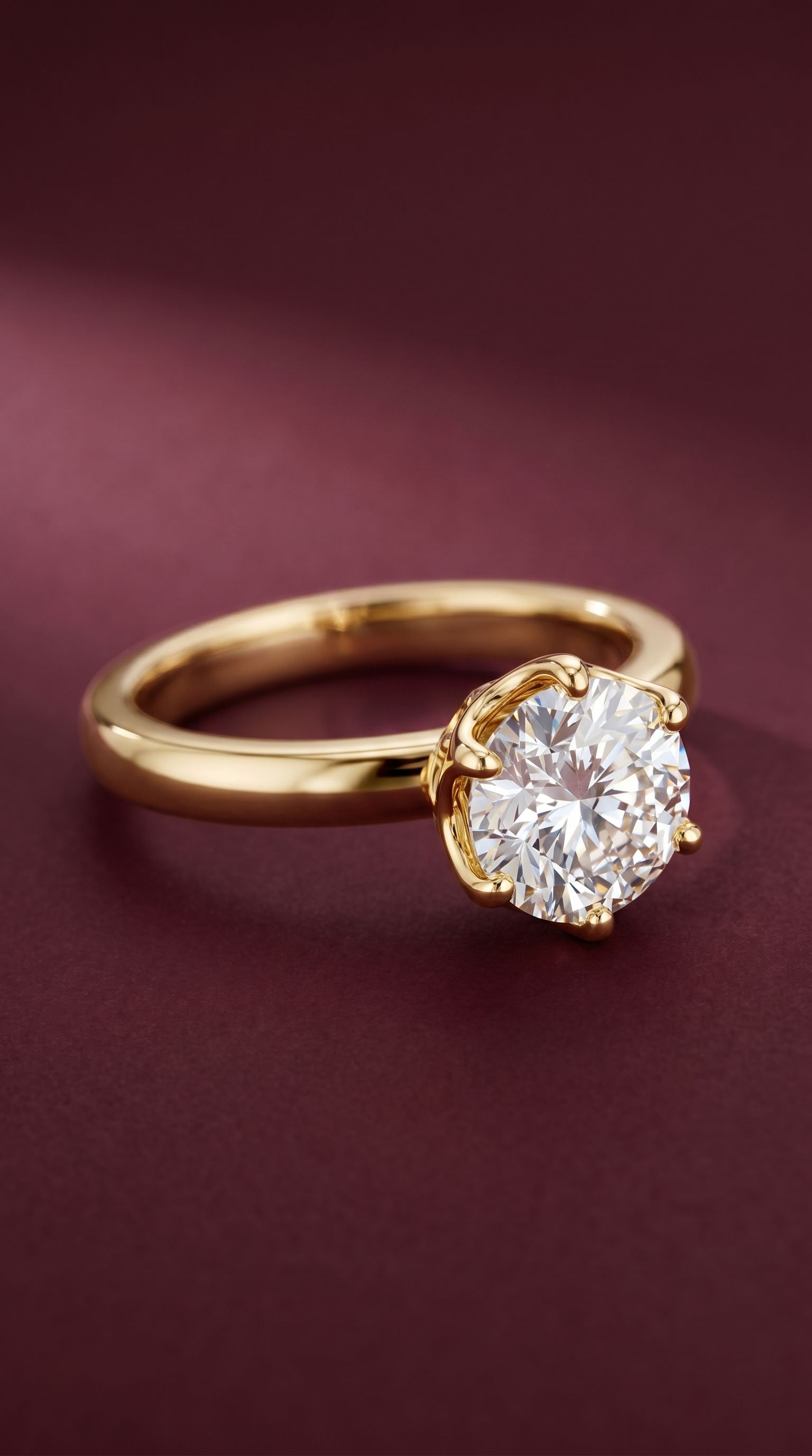 Round eight-prong statement ring on burgundy surface
